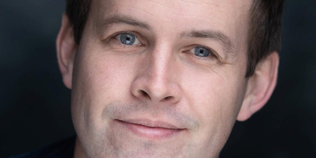 Close-up of Daniel Smales with a gentle smile, in a professional headshot.